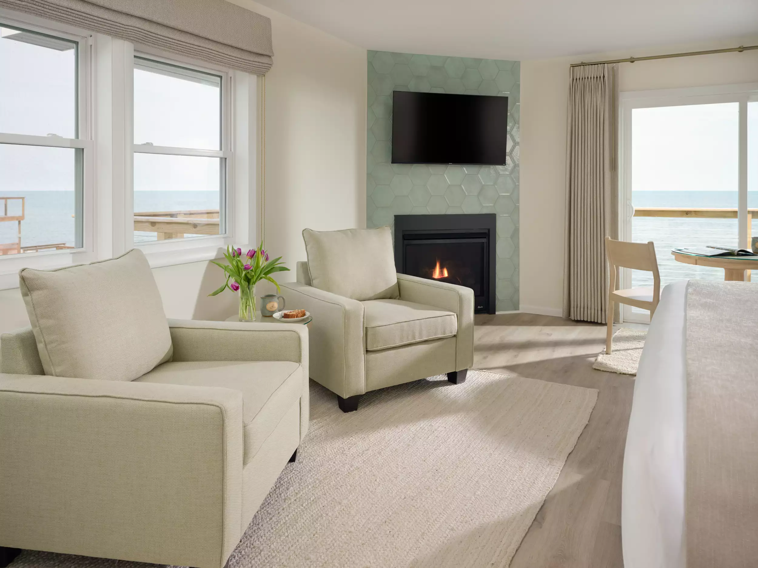 Plush chairs next to a gas fireplace with Lake Huron views